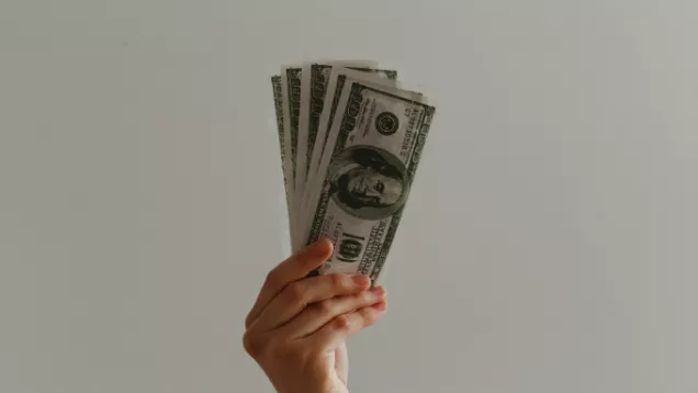 person holding stack of 100 dollar bills