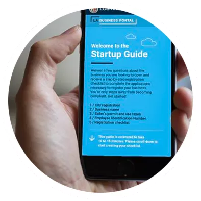 Image of phone displaying the LA Business Portal website. Welcome to the Startup Guide providing business resources and information for new businesses.